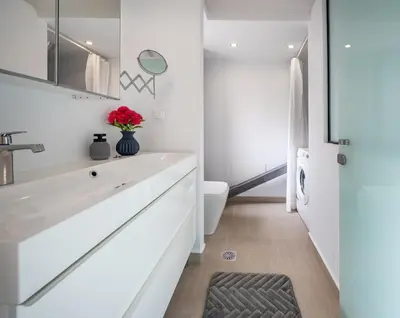 a white bathroom with a sink and a toilet at Omorphi Seaside Villa in Kalyves