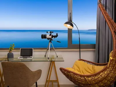a room with a table with a camera and a chair at Omorphi Seaside Villa in Kalyves