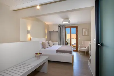a white bedroom with a bed and a couch at BŌW 2nd Floor Luxury Apt -Heart of Chania Old Town in Chania Town