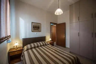a bedroom with a bed and two night stands and two lamps at Lila Villas in Stalos