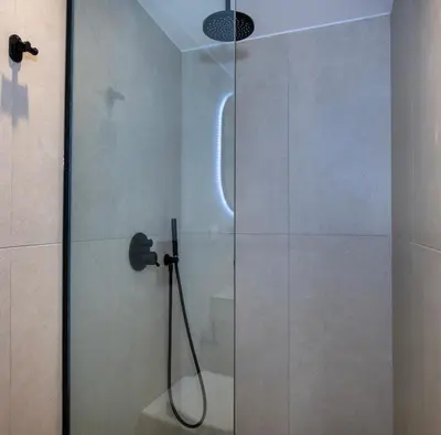 a shower with a glass door in a bathroom at Bow Complex Apartment- In the Heart of Old Harbour in Chania Town