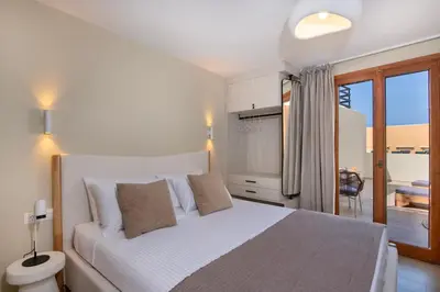 a bedroom with a white bed and a balcony at Bow Complex Apartment- In the Heart of Old Harbour in Chania Town