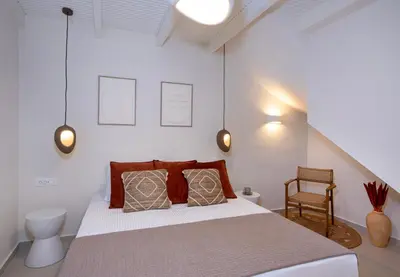 a bedroom with a large bed and a chair at Bow Complex Apartment- In the Heart of Old Harbour in Chania Town