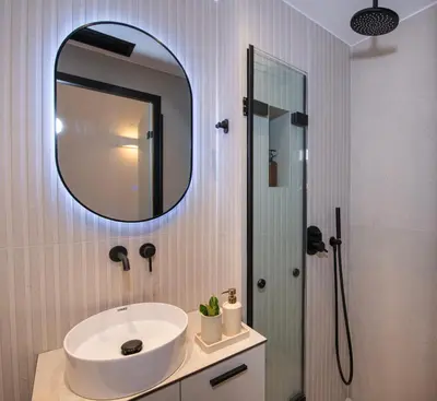 a bathroom with a sink and a mirror at Bow Complex Apartment- In the Heart of Old Harbour in Chania Town