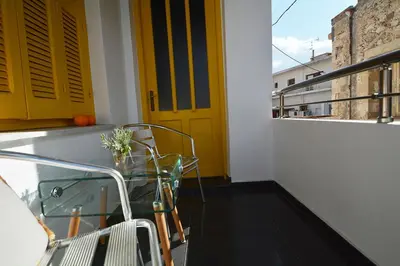 a yellow door on a balcony with a glass table at Agapi in Kissamos