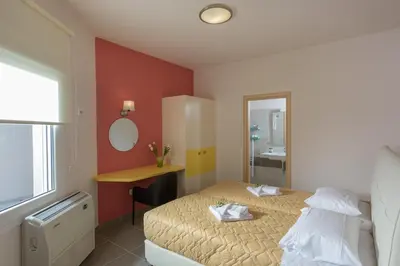 a bedroom with a bed and a desk and a mirror at Koukos Villas in Stalos