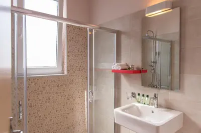 a bathroom with a shower and a sink and a mirror at Koukos Villas in Stalos