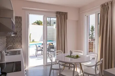 a kitchen and dining room with a table and chairs at Koukos Villas in Stalos