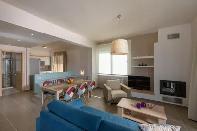 a living room with a blue couch and a table at Koukos Villas in Stalos