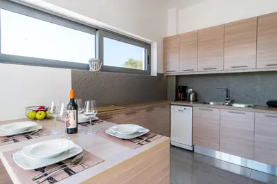 a kitchen with a table with glasses and wine bottles at Villa Alen in Áptera