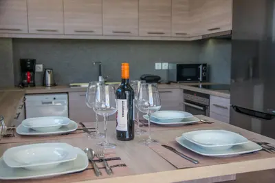 a table with a bottle of wine and two wine glasses at Villa Alen in Áptera