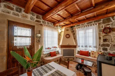 a living room with a table and a tv at Maria's Serene Countryside Retreat in Chania Town