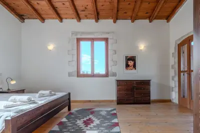 a white bedroom with a bed and a window at Vamos villa in Vamos