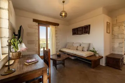 a living room with a couch and a table at Villa Falcos by PosarelliVillas in Gavalochori