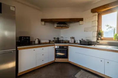 a kitchen with white cabinets and an oven at Villa Falcos by PosarelliVillas in Gavalochori