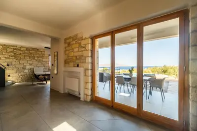 a dining room with a fireplace and a table with chairs at Villa Seiri by PosarelliVillas in Gavalochori