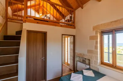 a bedroom with a bed and a staircase in a house at Villa Lavidona by PosarelliVillas in Gavalochori