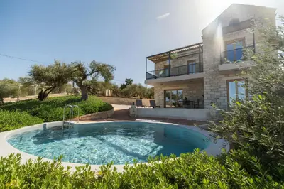 a swimming pool in front of a house at Villa Lavidona by PosarelliVillas in Gavalochori