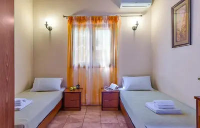 a room with two beds and a window at Villa Olive Xrisi in Kafoúros