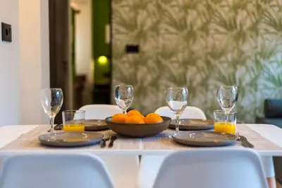 a table with a bowl of oranges and wine glasses at Chania Experience Residence in Chania Town