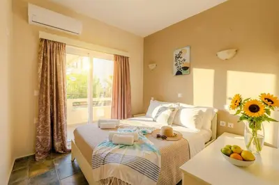 a bedroom with a bed and a table with a bowl of fruit at Ilios Mare Hotel in Agia Marina Nea Kydonias