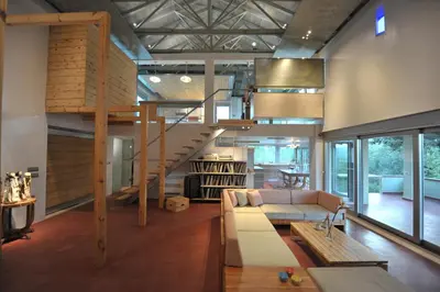 a living room with a couch and a spiral staircase at The Architect's House in Neo Chorio in Néon Khoríon
