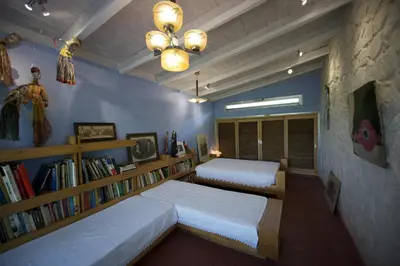 a bedroom with two beds and a book shelf at The Architect's House in Neo Chorio in Néon Khoríon