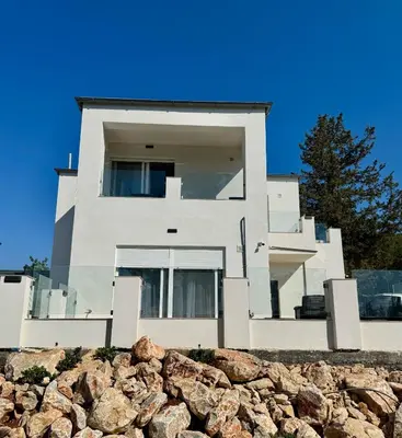 a white house with a wall of rocks at Villa & Apartament Armonia 2 Sol Aura Gavalochori - Vamos KRETA in Vamos