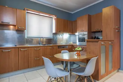 a kitchen with wooden cabinets and a wooden table and chairs at Kafkales Penthouse Chania Old Town in Chania Town