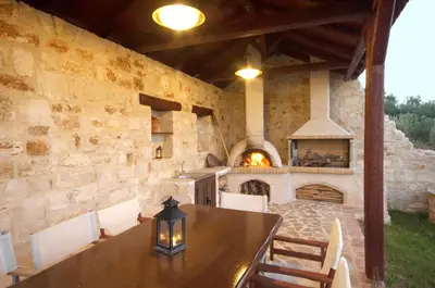 a dining room with a table and a fireplace at Dream Hill Villas in Tavronitis