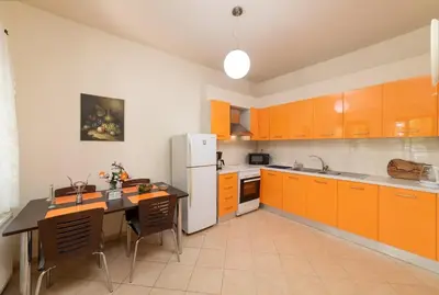 a kitchen with orange cabinets and a white refrigerator at 3-Min Drive to Kalyves Beach, Stone Villa in Armenoi next to Cafés & Taverns by the Natural Water Springs in Arménoi