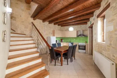 a kitchen and dining room with a wooden table and chairs at 3-Min Drive to Kalyves Beach, Stone Home with Private Pool in Armenoi Center in Arménoi