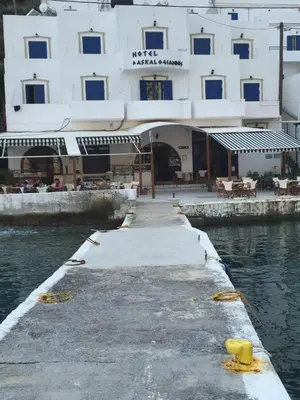 a building with a dock next to a body of water at Daskalogiannis Hotel in Loutro
