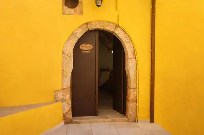an entrance to a yellow wall with an archway at SternesVillage, Middle Ground Floor in Stérnai