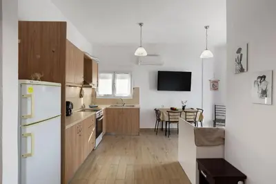 a kitchen with a white refrigerator and a table at Cozy Apartment Next To The Beach In Almyrida -BY APOKORONAS VILLAS in Almirida