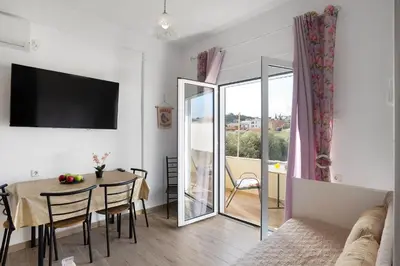 a living room with a table and a dining room at Cozy Apartment Next To The Beach In Almyrida -BY APOKORONAS VILLAS in Almirida