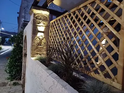 a wooden fence with plants on the side of a building at Violetta Kaliviani room 1 in Kalivianí