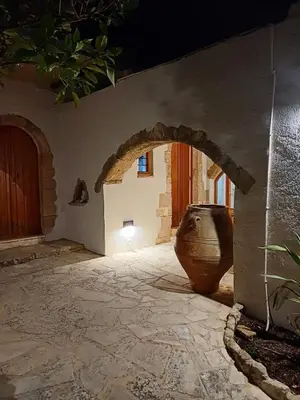 a stone courtyard with a large vase in a building at Violetta Kaliviani room 1 in Kalivianí