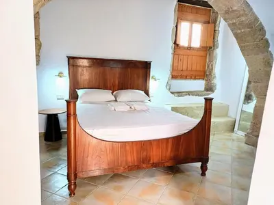 a bedroom with a wooden bed in a room at Violetta Kaliviani room 1 in Kalivianí