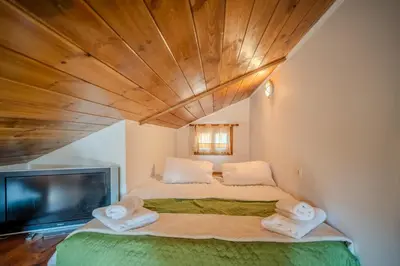 a bedroom with a bed and a flat screen tv at Traditional Art House Armenoi in Arménoi