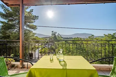 a yellow table with two glasses on top of a balcony at Traditional Art House Armenoi in Arménoi