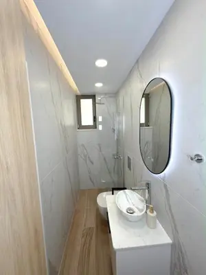 a white bathroom with a sink and a mirror at Cozy Suite Palaiochora Sea View, Jacuzzi, Top WiFi in Palaiochóra