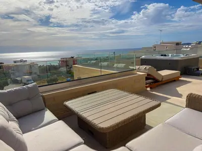 a balcony with a couch and a view of the ocean at Cozy Suite Palaiochora Sea View, Jacuzzi, Top WiFi in Palaiochóra