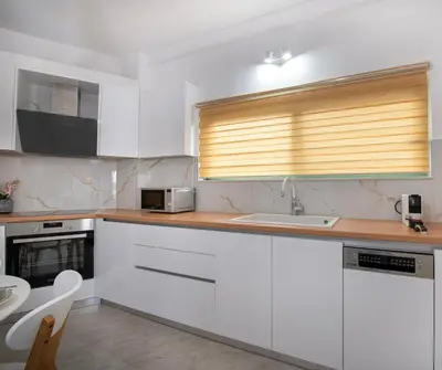 a kitchen with white cabinets and a sink at KHORA Apartment- 40m to Sandy Beach in Chania Town