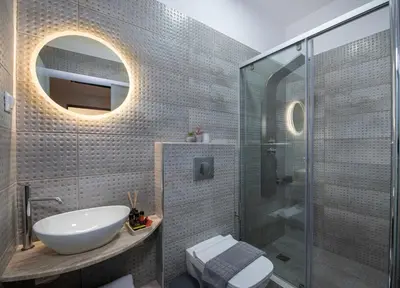 a bathroom with a sink and a glass shower at KHORA Apartment- 40m to Sandy Beach in Chania Town