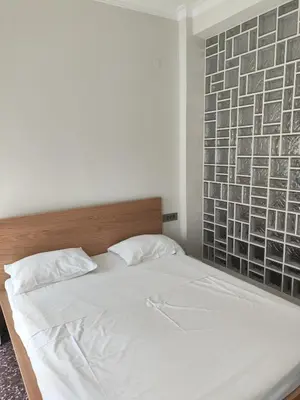 a bedroom with a white bed with a brick wall at Apartment Near Beach & Old Port in Chania Town