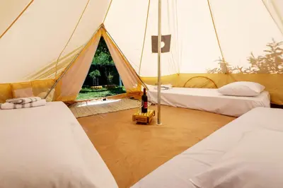 a tent with two beds and a person standing inside at Edem private camping in Análipsis