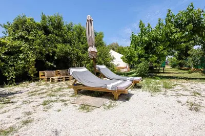 two lounge chairs and an umbrella in a field at Edem private camping in Análipsis