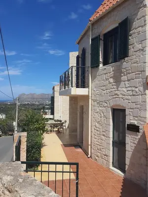 a stone house with a balcony and a table at Despoinas House in Kounoupidhianá