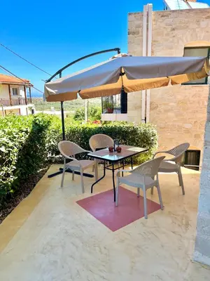 a table and chairs under an umbrella on a patio at Despoinas House in Kounoupidhianá